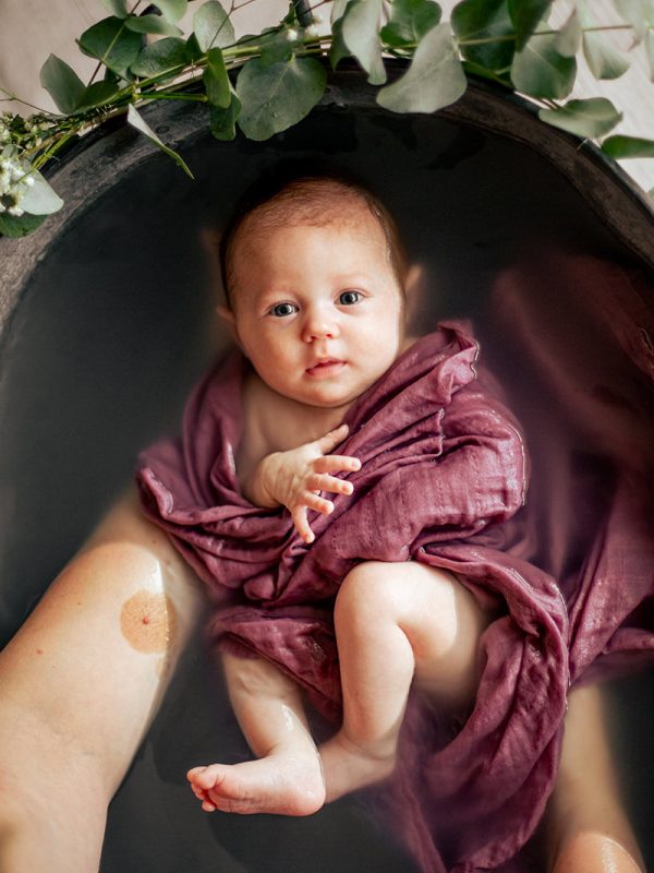 photo d'un bébé emmailloté dans une baignoire en zinc