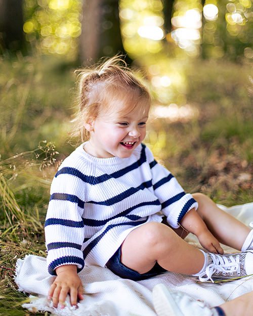 photo d'un enfant assis dans la forêt en train de rigoler dans l'Eure