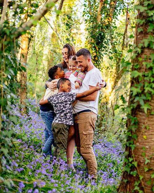 photo d'une famille aimante au milieu de fleurs violettes de foret en Normandie
