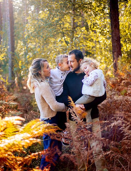Photo d'une famille heureuse dans la forêt au milieu des fougères en Normandie